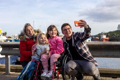 Man and woman taking photos with siblings