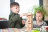 Two young boys play jenga at the table, representing fostered siblings