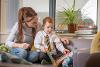 Woman helping a young boy to read representing a teacher who fosters and the child they care for